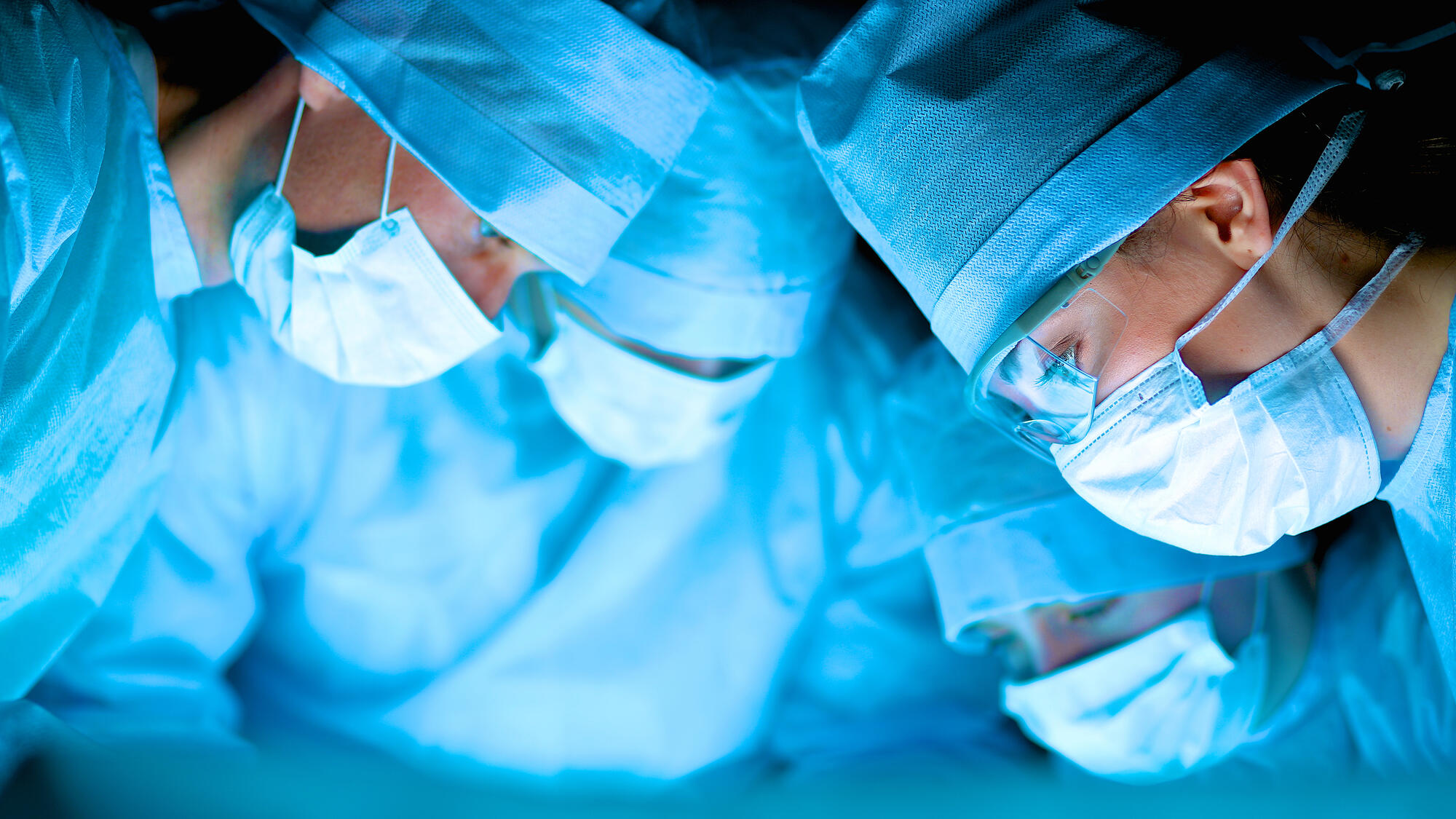 Surgeons huddled over the surgical table