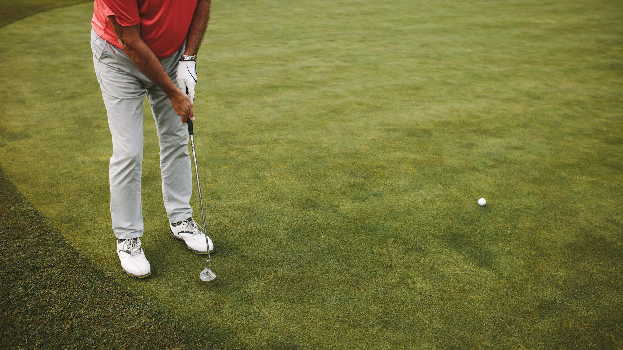 man putting on a golf course green